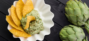 Roasted artichoke spread with tortilla chips and fresh artichokes