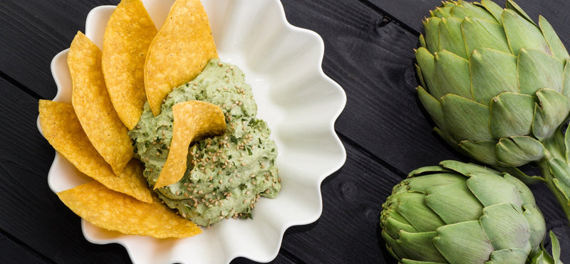 Roasted artichoke spread with tortilla chips and fresh artichokes