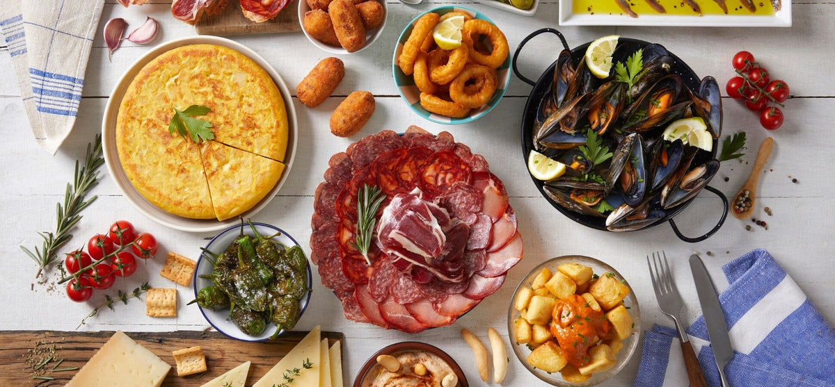 Spanish tapas spread with tortilla, seafood, cured meats, peppers and patatas bravas