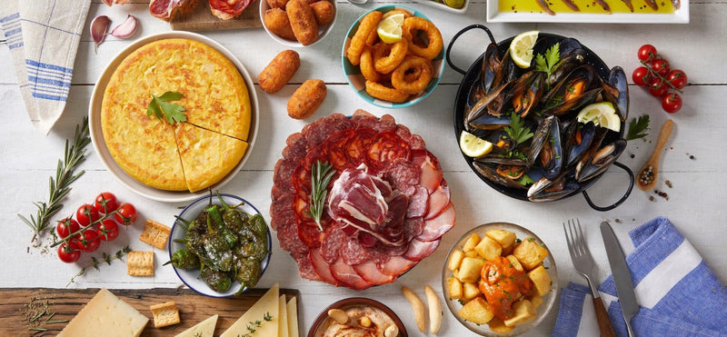 Spanish tapas spread with tortilla, seafood, cured meats, peppers and patatas bravas